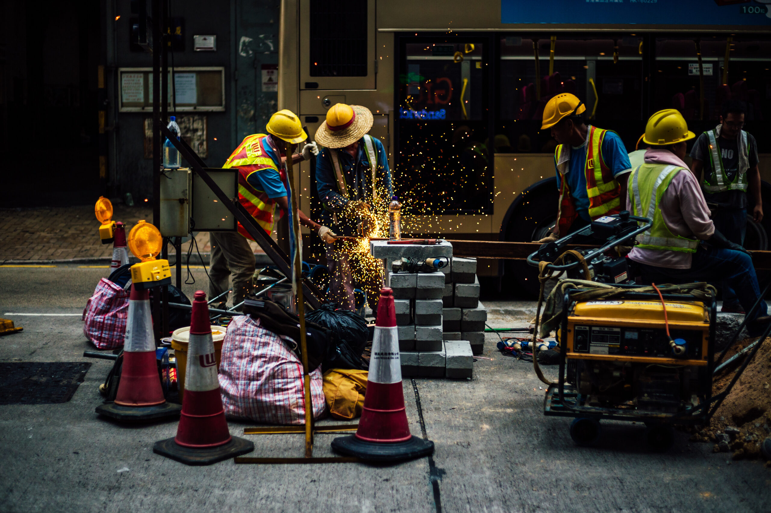 Manual Workers Working On Road Against Bus